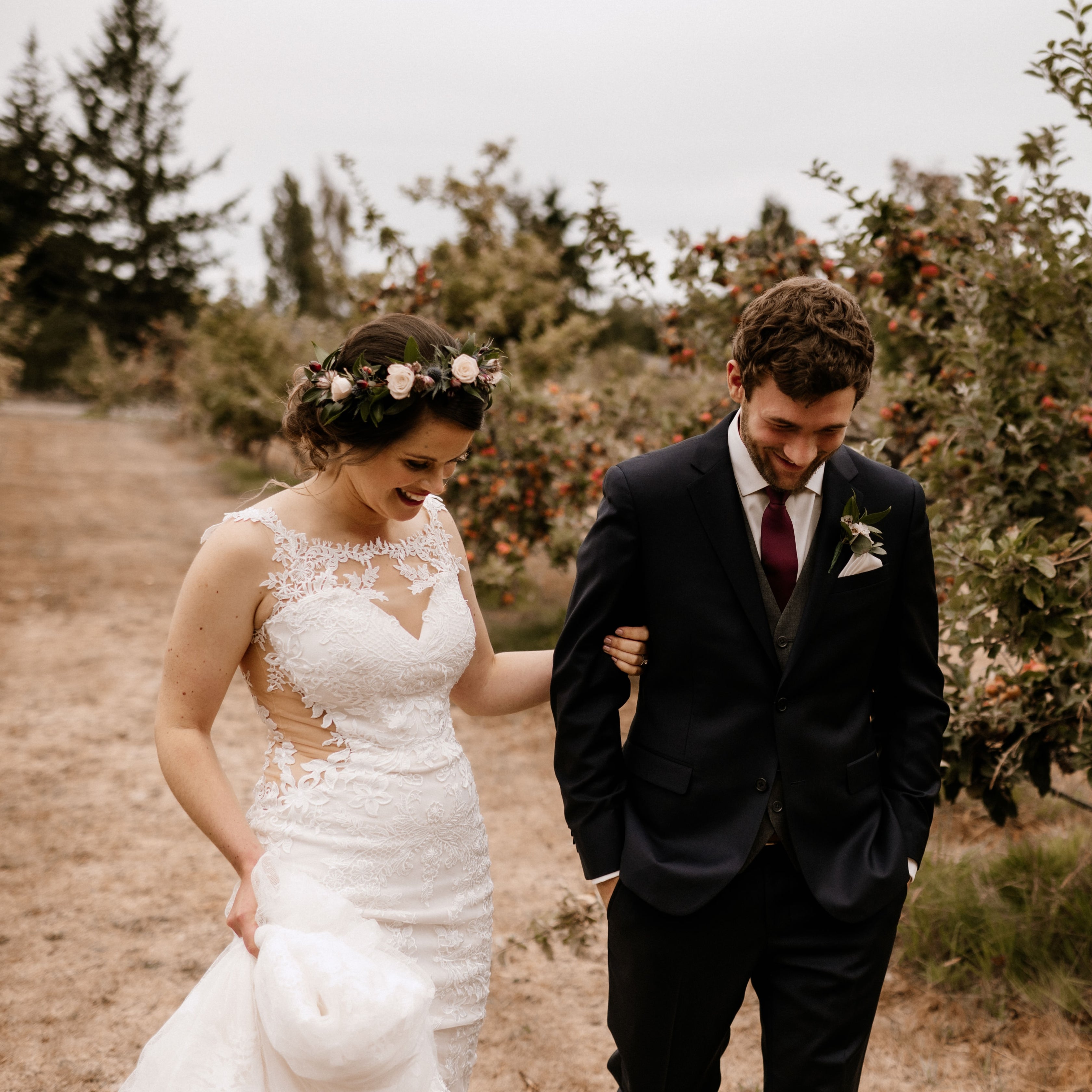 Newlyweds walking a row of the organic apple orchard at Sea Cider